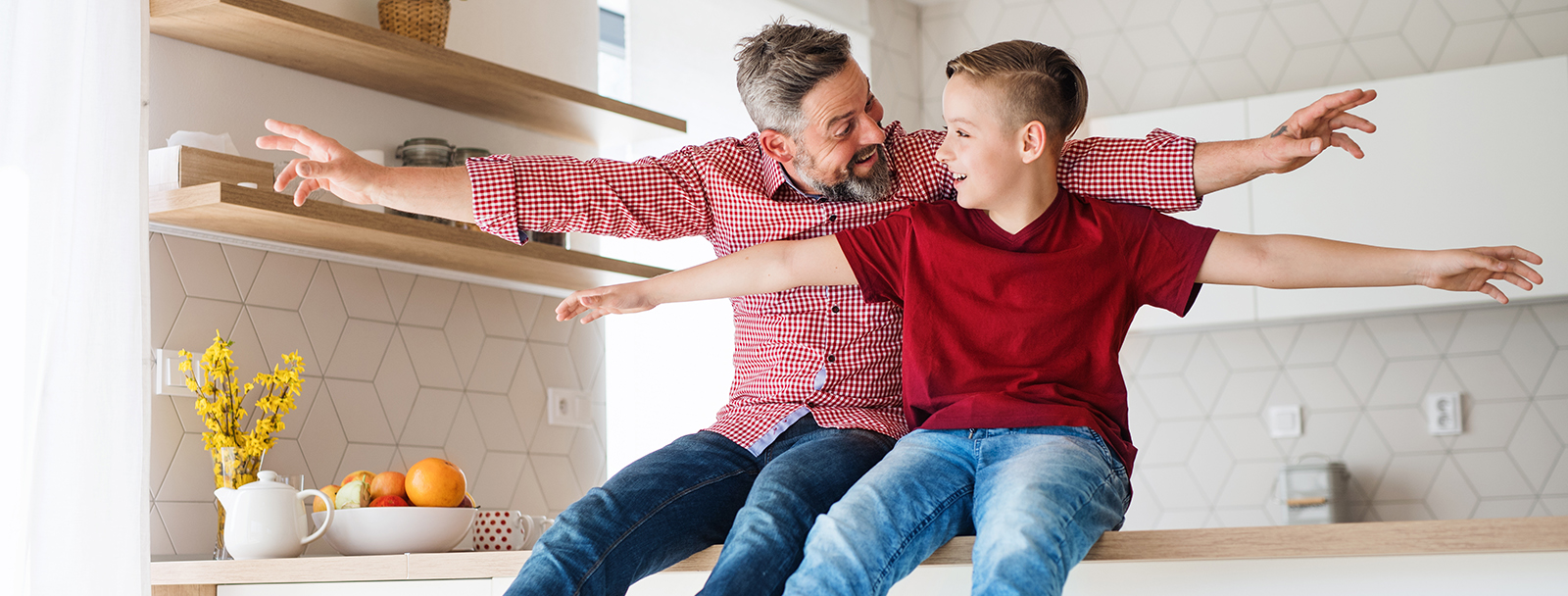 Dad and Son Sitting On Counter Red Shirts